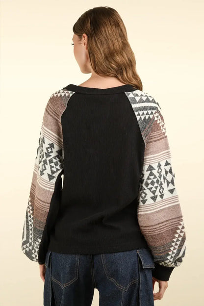 Black and multicolored printed long sleeve knit top with round neck and geometric designs