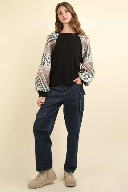 Black and white printed long sleeve round neck knit top with patchwork design and beige boots