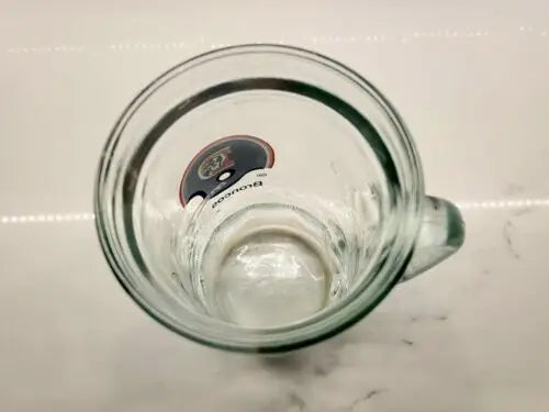 Empty glass beer mug featuring Denver Broncos NFL Football design from the 1980s