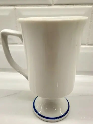 White pedestal mug with blue trim featuring Red Coats Revolutionary War design