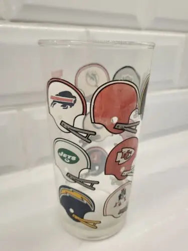 Glass cup with NFL American football conference helmet logos for American football fans