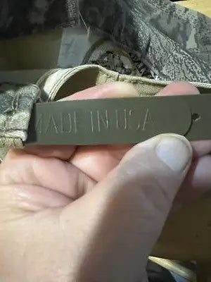 Olive green Made in USA tag held in hand on Vintage Wolf Mountain SnapBack Hat