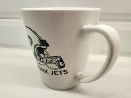 White ceramic coffee mug featuring a green football helmet with NY Jets logo