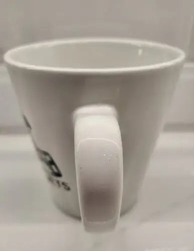 White ceramic coffee mug with handle featuring York Jets logo in green ceramic design