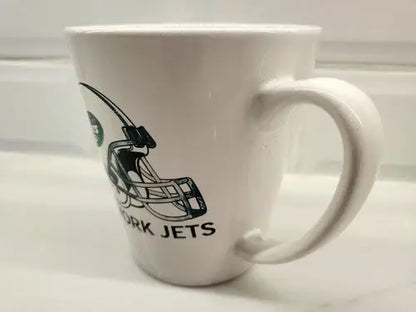 White coffee mug featuring New York Jets logo on green ceramic design