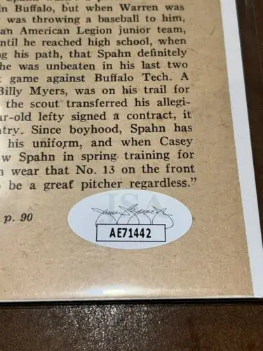 Autographed sport magazine page featuring Warren Spahn with JSA authentication sticker