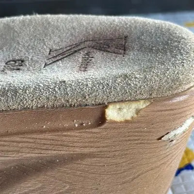 Worn shoe sole with damage and fuzzy insole of White Mountain leather slide sandals