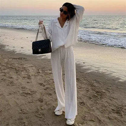 Woman on beach wearing women tracksuits shirt with long pants two-piece set and black handbag