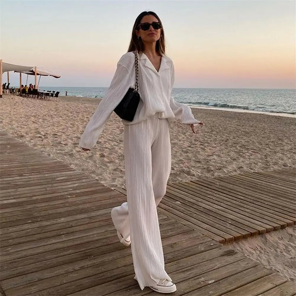 Women tracksuits shirt with long pants two-piece set worn by a woman in white pleated outfit