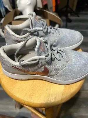 Light gray Nike Flex Contact running shoes with copper Nike swooshes for women