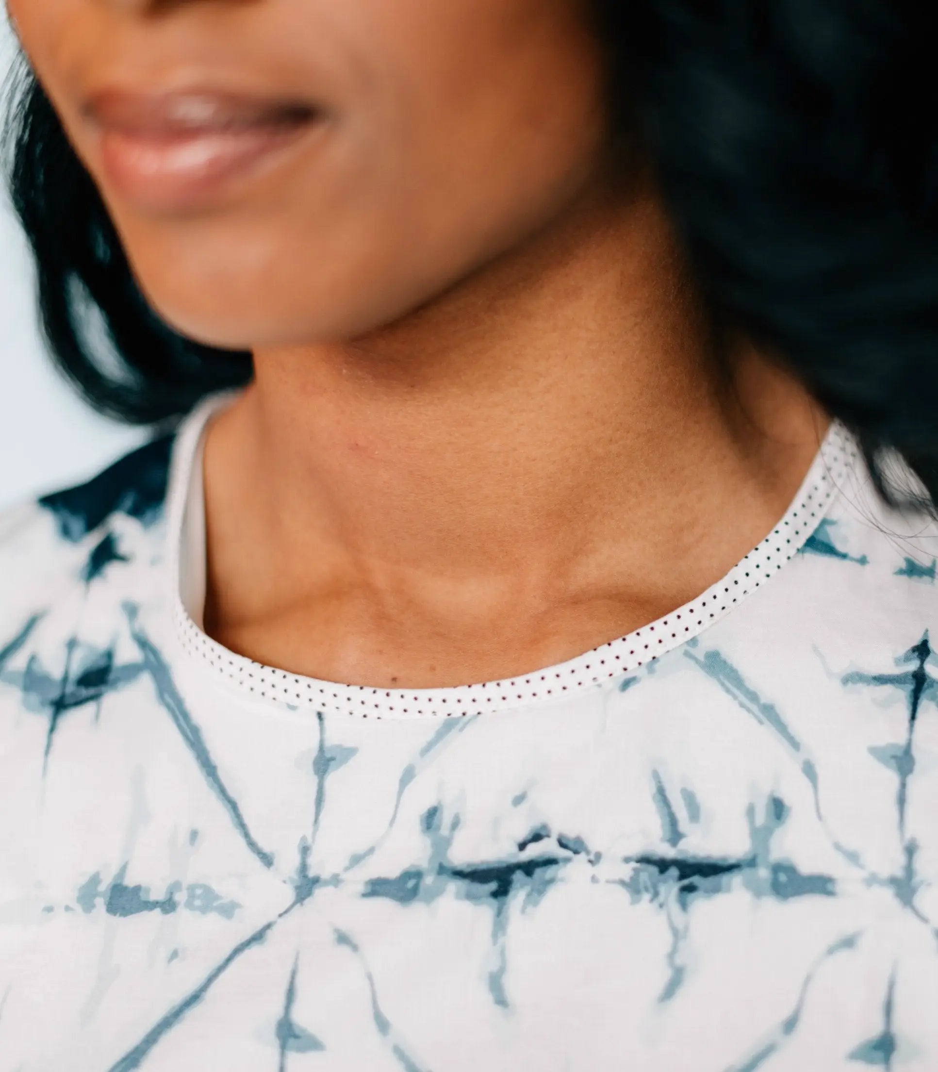 Woman wearing a white and blue tie-dye woven slim fit dress with dotted trim neckline