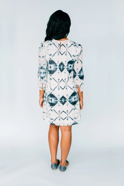 Woman modeling a woven slim fit dress with black and white tie-dye pattern and three-quarter sleeves