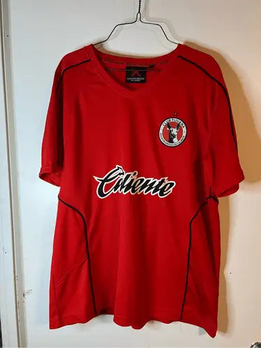 Red short-sleeved athletic soccer jersey with black trim and white logos