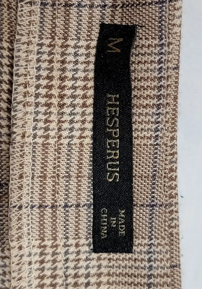 Black clothing tag on brown beige houndstooth fabric with blue plaid pattern for Y2K plaid mini skirt