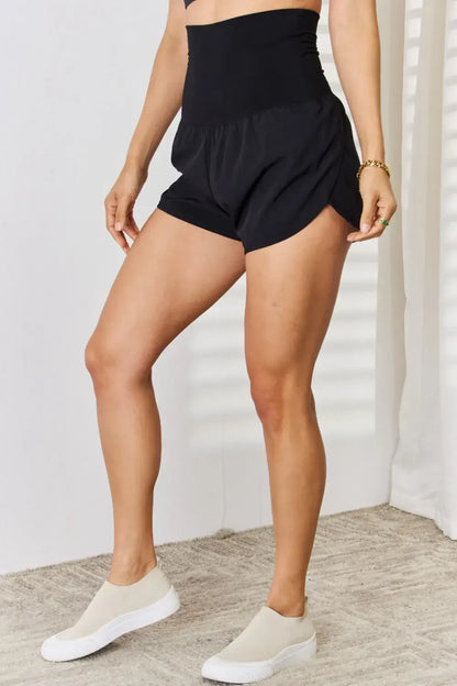 Black high-waisted athletic shorts with tummy control and sleek elastic waistband