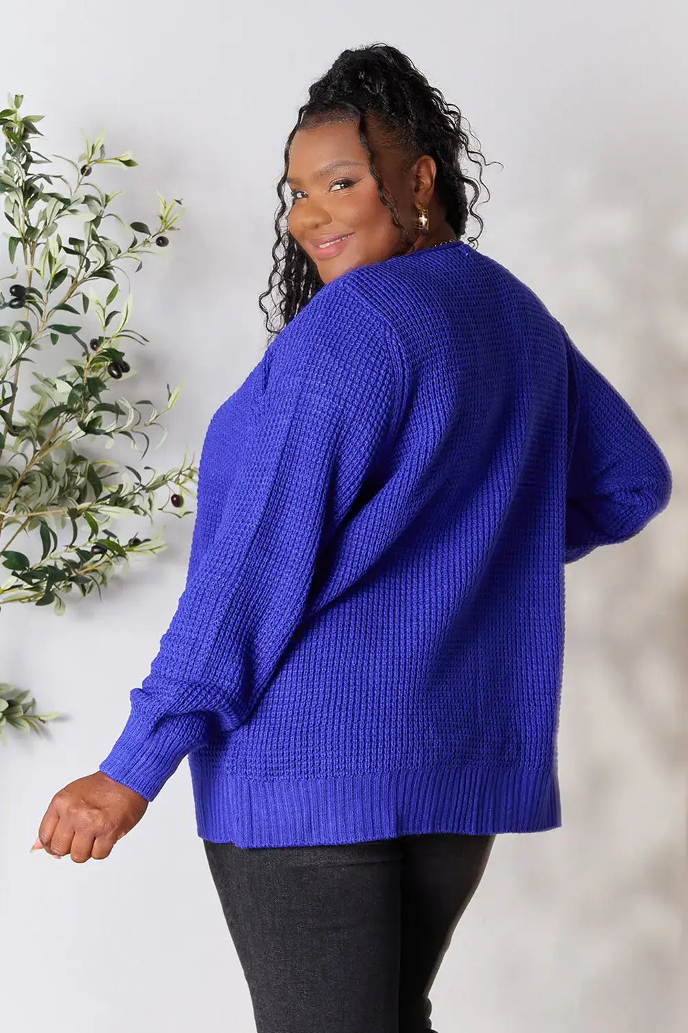 Plus-size woman in royal blue knit cardigan with relaxed fit and moderate stretch