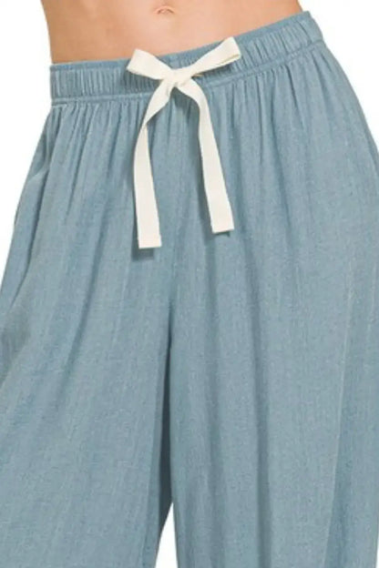 Light blue linen drawstring pants with white bow tie waistband for a stylish look