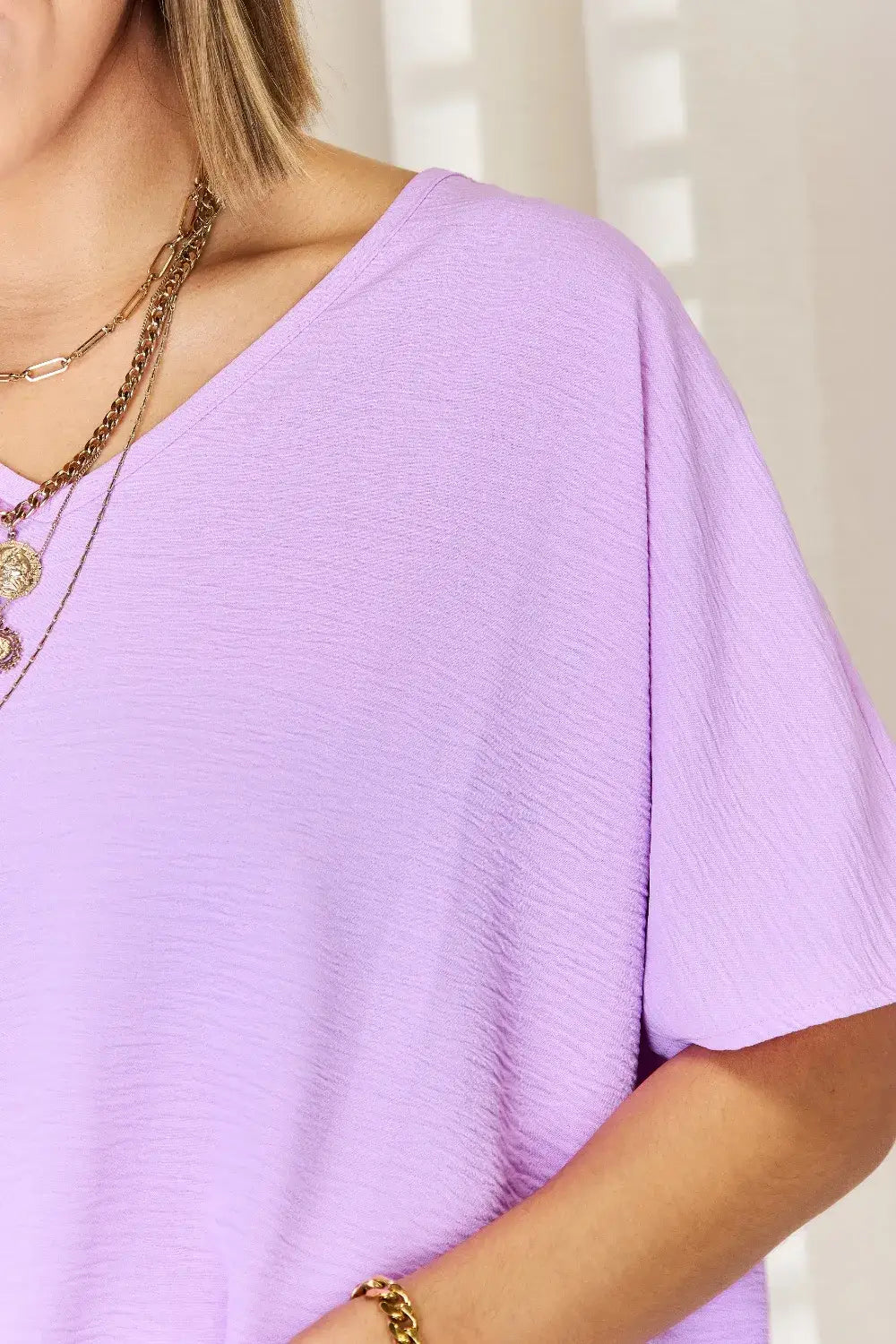 Lavender v-neck blouse with short sleeves and layered necklaces, texture short sleeve style