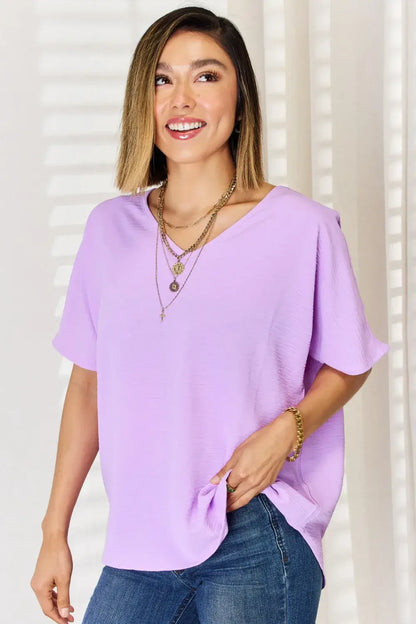 Lavender V-neck blouse with ruffled sleeves and layered necklaces, perfect for texture short sleeve style