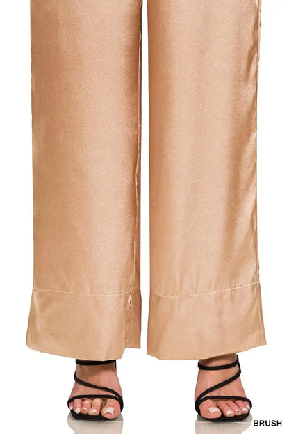 Gold satin wide-leg satin pants with cuffed hems paired with strappy sandals